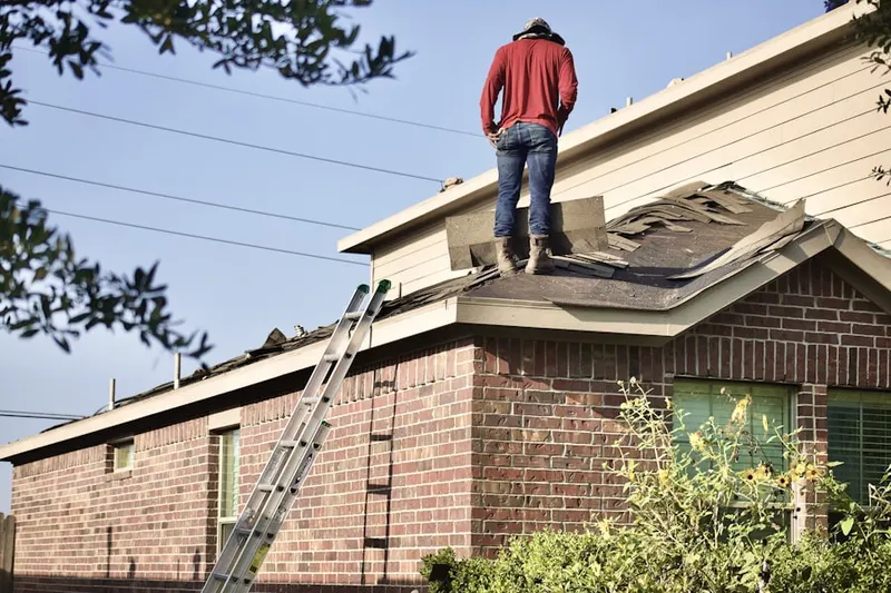 Professional roofer working on a residential roof in Huntington Bay